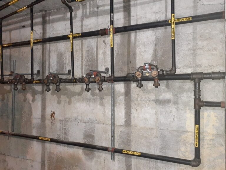 Pipes and valves on concrete wall.