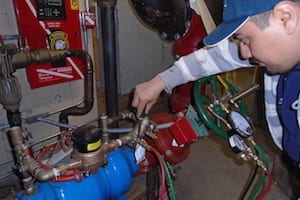 Technician inspecting complex plumbing system setup.